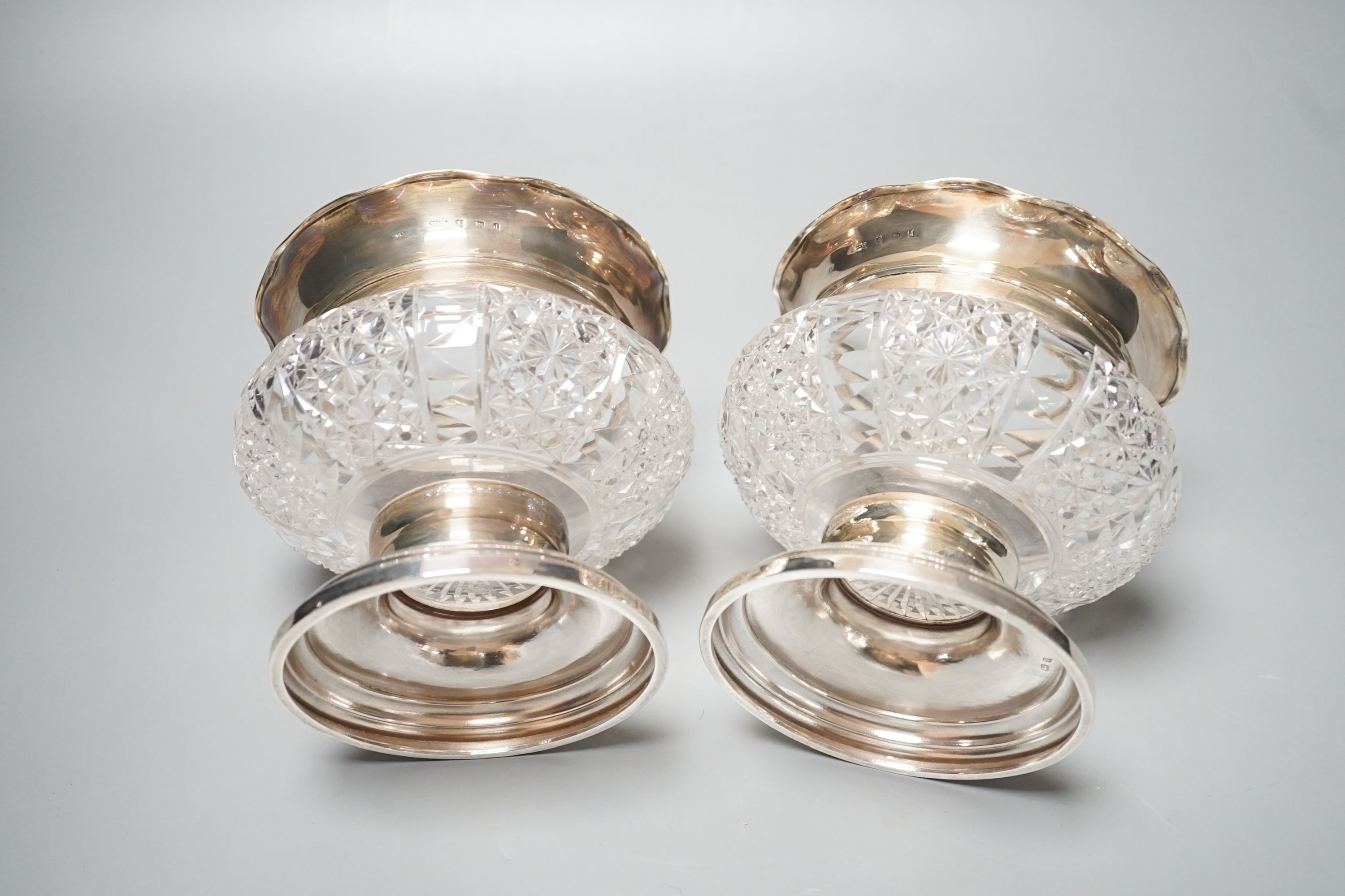 A pair of Edwardian silver mounted glass bowls, (lacking covers), Birmingham, 1904, height 13.4cm.